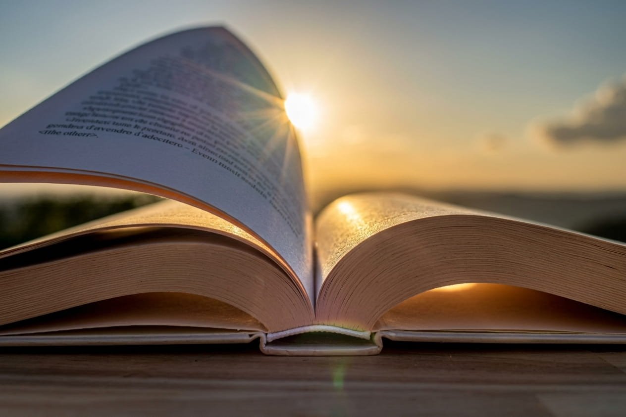Libro abierto iluminado por la luz del atardecer, símbolo del conocimiento y el aprendizaje